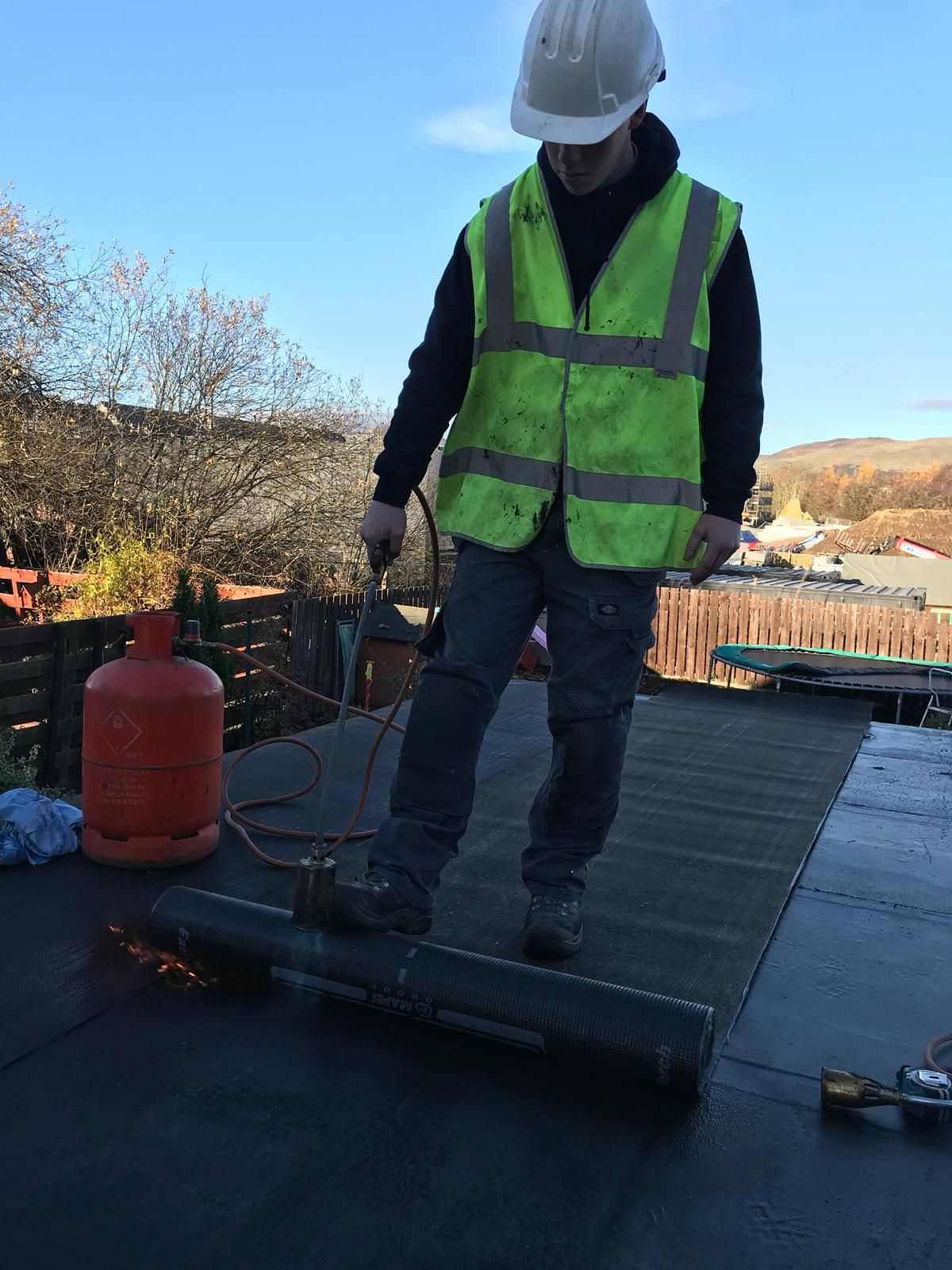 A picture of a flat roof being repaired by Prestige Roofing in Edinburgh. When choosing the right flat roof covering, you need to take several considerations into account, including the look you want to achieve, the size of your flat roof, the type of weather it’ll face, and the labour it will require.