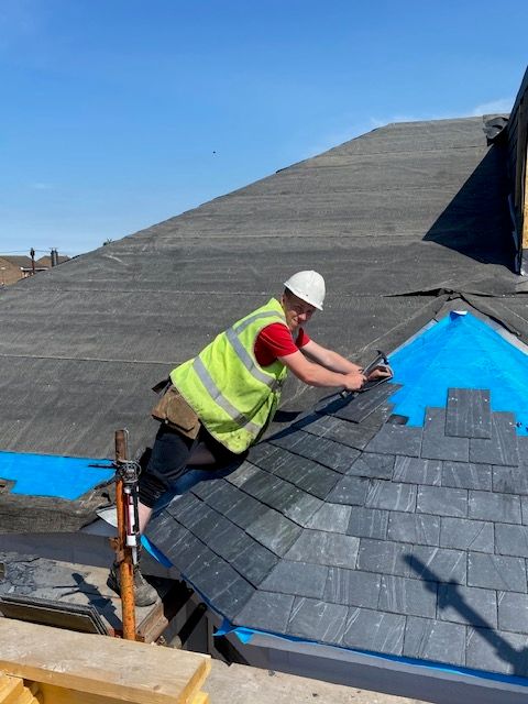 A picture of a roofer repairing and maintaining a slate roof in Edinburgh. Regular inspection and timely remedial work will save you money and protect your home from more problematic issues developing.