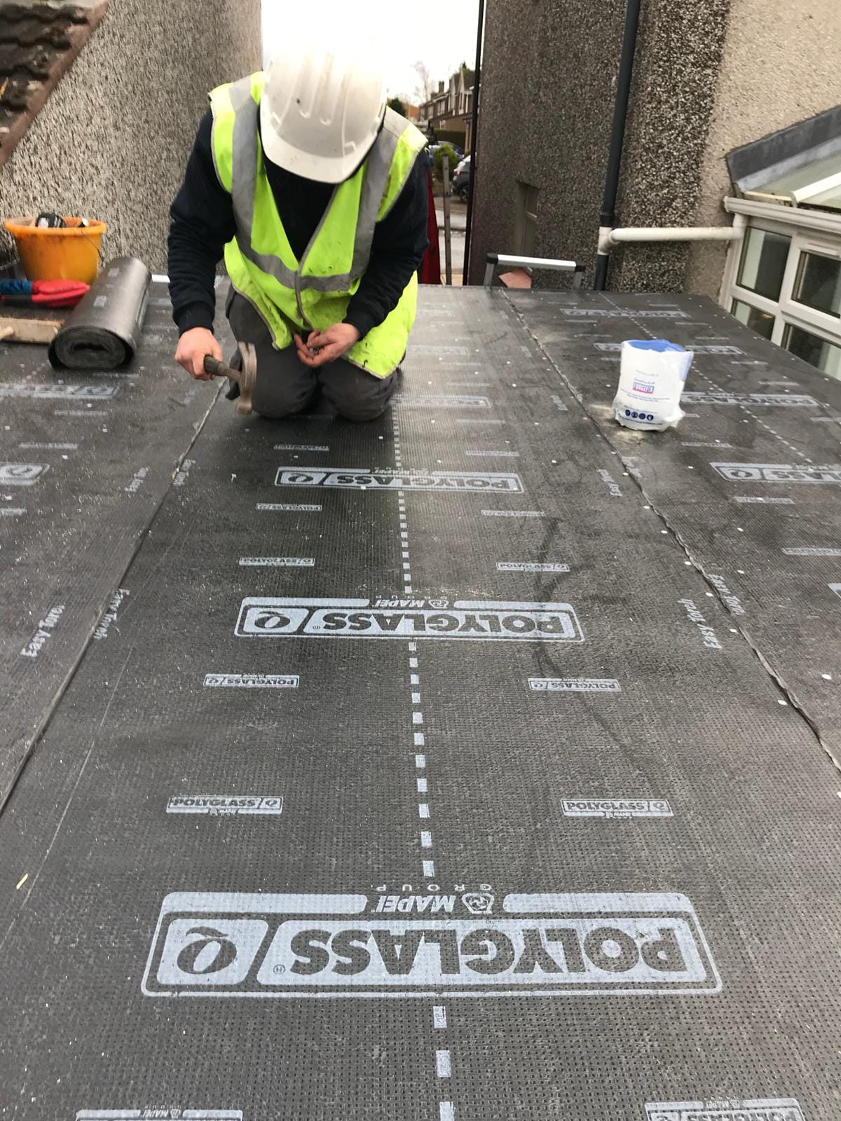 A picture of a flat roof being repaired by Prestige Roofing in Edinburgh. When choosing the right flat roof covering, you need to take several considerations into account, including the look you want to achieve, the size of your flat roof, the type of weather it’ll face, and the labour it will require.